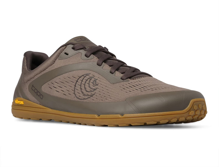 The TOPO Connect (Men’s) is a brown and tan minimalist shoe featuring a mesh upper, gum Vibram outsole, dark laces, and subtle branding on the side and heel. Its low-profile zero-drop design makes it ideal for both casual and athletic use.