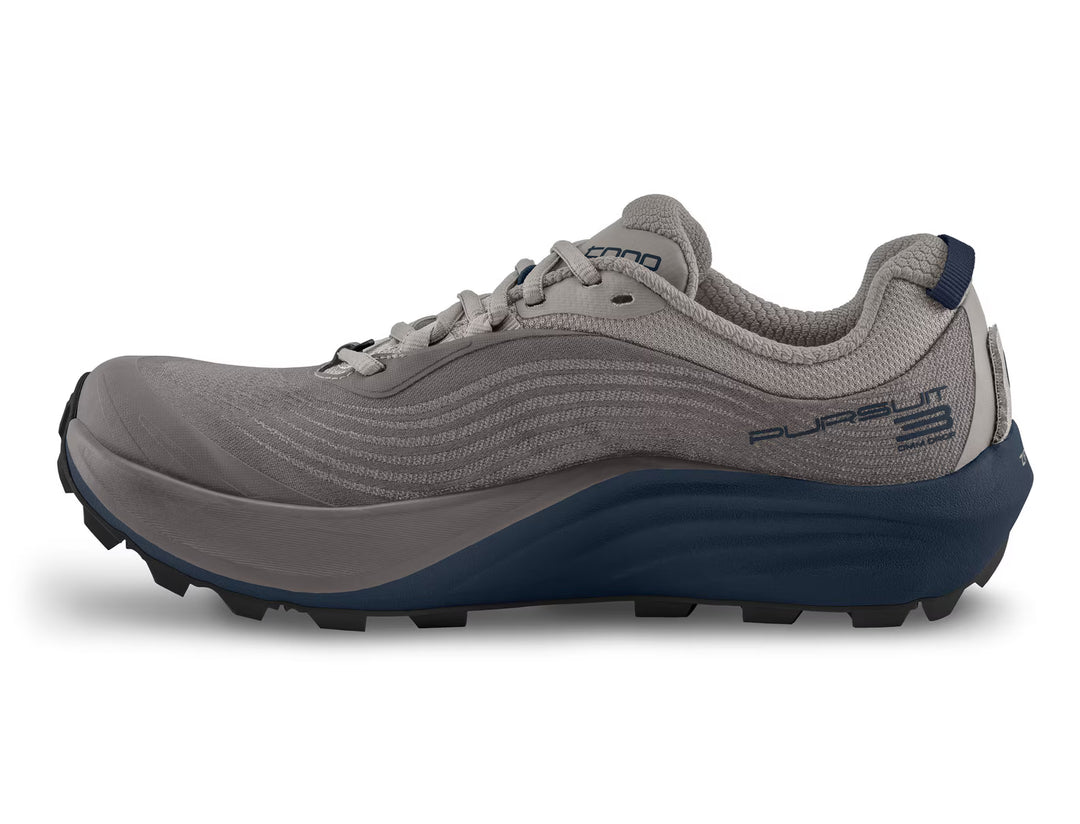 A gray men’s athletic trail running shoe from TOPO, the Pursuit 3 features a dark blue sole and heel, a wave-like side pattern, and PURSUIT 3 branding near the heel; designed as a zero drop trail runner to promote a more natural stride.
