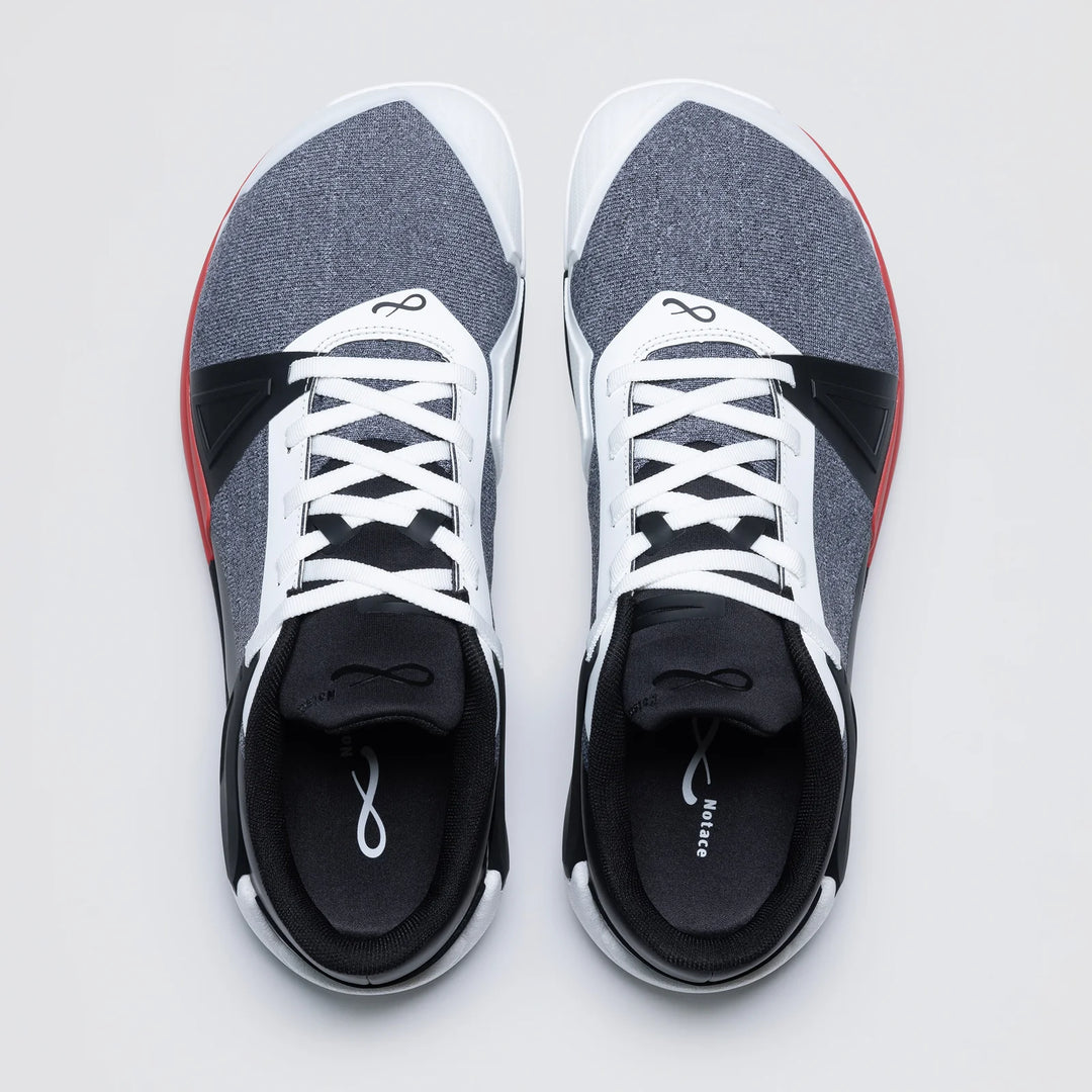 A top-down view shows the Notace KOTO 1 (Men's) gym shoes, featuring white laces, grey and black uppers with red side accents, and a white infinity symbol on the tongue. They’re designed for multidirectional control and rest side by side on a light background.