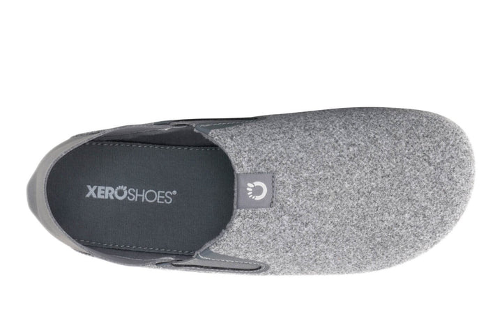 Top view of the Pagosa (Men's) grey slip-on shoe featuring a soft, textured upper, rounded toe, black insole labeled Xero Shoes, and a small fabric tag near the opening.