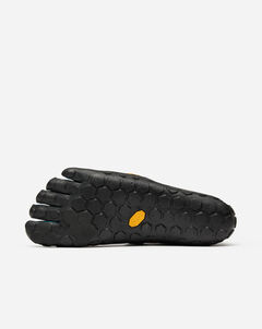 The Vibram Scramkey (Unisex) is a black minimalist shoe with a Megagrip Elite sole, five-toe design, and hexagonal tread. A small yellow logo sits near the arch against a plain white background—ideal minimalist outdoor gear.