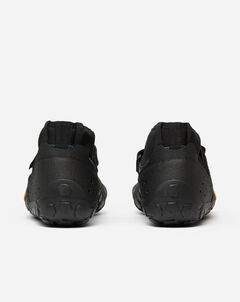 A pair of Vibram Scramkey (Unisex) black minimalist outdoor shoes, shown from the back with Megagrip Elite textured rubber soles and heel details, set against a plain white background.