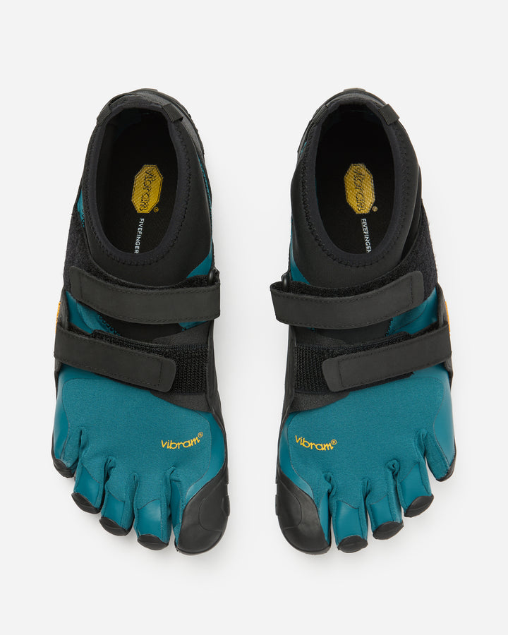 A pair of Vibram Scramkey (Unisex) teal and black minimalist outdoor shoes with individual toe pockets, Velcro straps, yellow branding, and Traction Lug technology is shown from above on a plain white background.