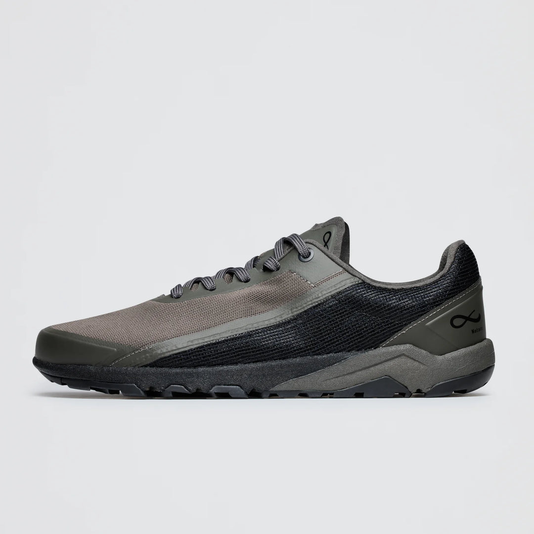 The Notace Yama T1 (Men's) is a low-top trail shoe in grey and black with a mesh upper, textured side panel, black laces, minimalist infinity logo near the heel, and a light grey sole designed for all-day comfort.