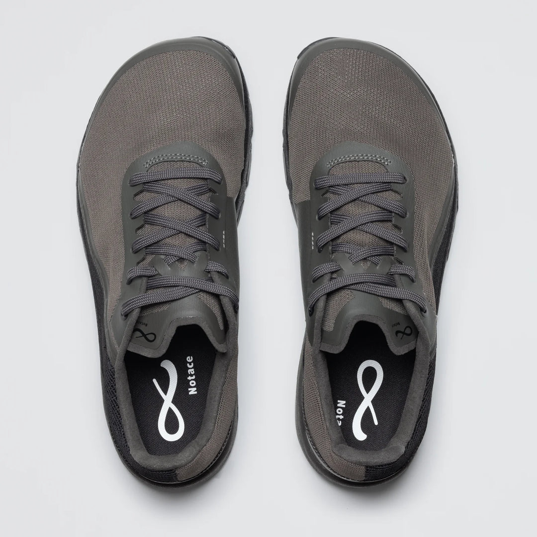 A top view of Yama T1 men's trail shoes by Notace in gray with black soles. Featuring laces and all-day comfort, the insoles show a white infinity symbol and the word "NoLace.