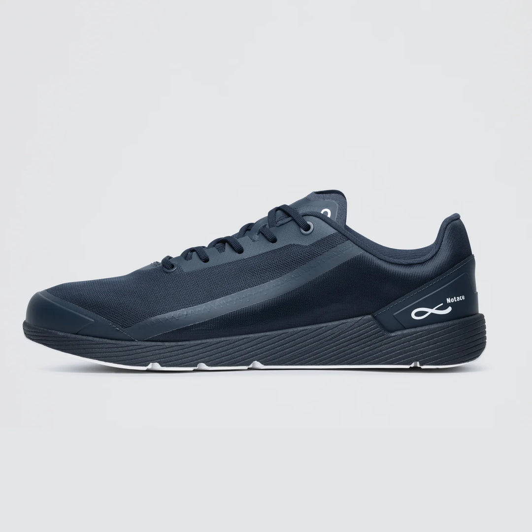 The Notace Michi 1 (Women's) is a black low-profile athletic sneaker featuring a mesh upper, eTPU midsole, lace-up closure, and a white infinity logo on the heel, shown against a plain white background.