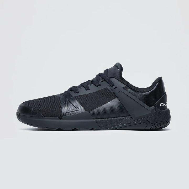 The Notace KOTO 1 (Men's) is a black athletic court shoe featuring a low profile, mesh upper, synthetic overlays, and a geometric side support structure for multidirectional control, displayed on a plain light gray background.
