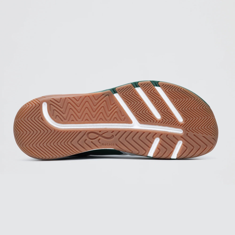 The image shows the sole of Notace's KOTO 1 (Men's) gym shoe with a light brown rubber bottom, herringbone tread, white accents, and a small logo near the center, designed for multidirectional control and support.