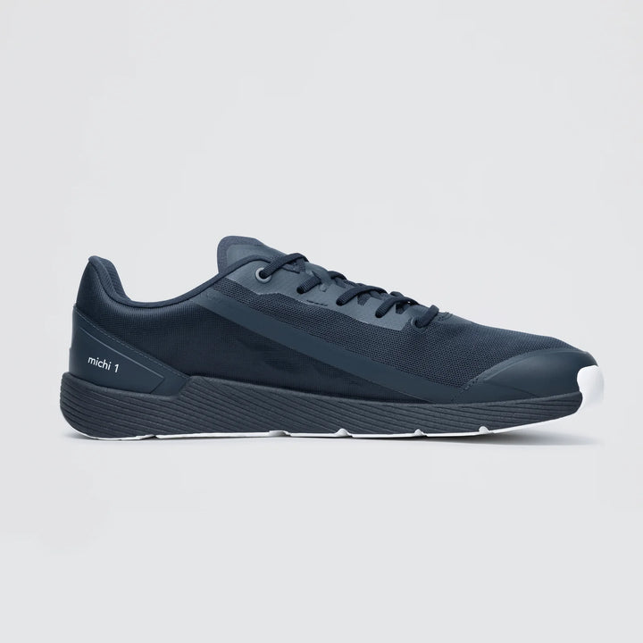 A side view of the Notace Michi 1 (Men's), a dark navy blue lightweight road-to-gym shoe with a white sole, eTPU midsole, and "mich 1" on the heel, shown against a plain light background.