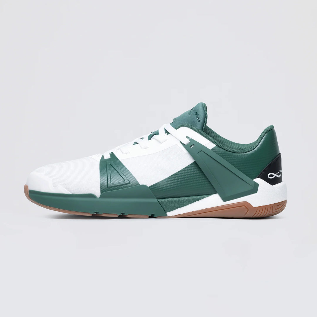 The Notace KOTO 1 (Men's) court shoe features a white and green upper, gum sole, black heel accents, and white laces for multidirectional control. Displayed in side profile against a plain light gray background.
