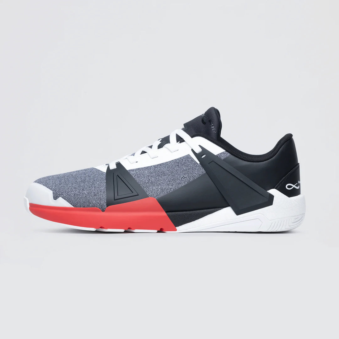 The Notace Koto 1 (Women's) is a modern athletic sneaker with a gray mesh upper, black and white overlays, white laces, red accent by the sole, and an infinity symbol on the heel. Its sleek geometric design offers grounded stability.