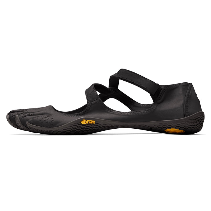 The Vibram V-Soul (Women’s) is a black barefoot shoe with individual toe pockets, a flat sole, and a Velcro strap over the foot, shown from the side on a white background—ideal as Pilates or yoga shoes.