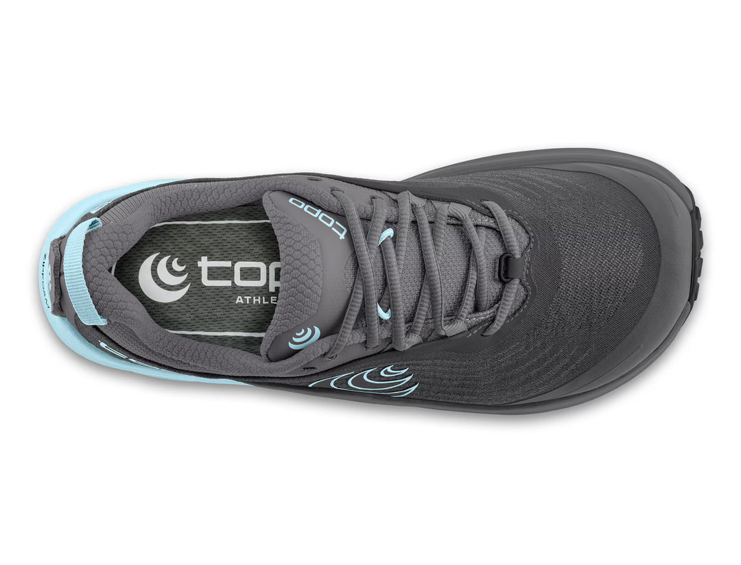Top view of the TOPO Pursuit 3 (Women’s) gray athletic shoe, featuring light blue accents, black laces, and a durable Vibram Megagrip outsole for outstanding traction. The cushioned platform enhances comfort, while the insole displays the TOPO logo and branding printed in white.