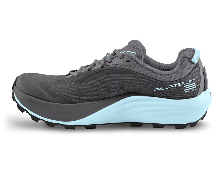 A side view of the TOPO Pursuit 3 (Women’s) in gray and light blue, featuring black laces, a textured sole with a Vibram Megagrip outsole, a cushioned platform, and Pursuit branding on the heel.