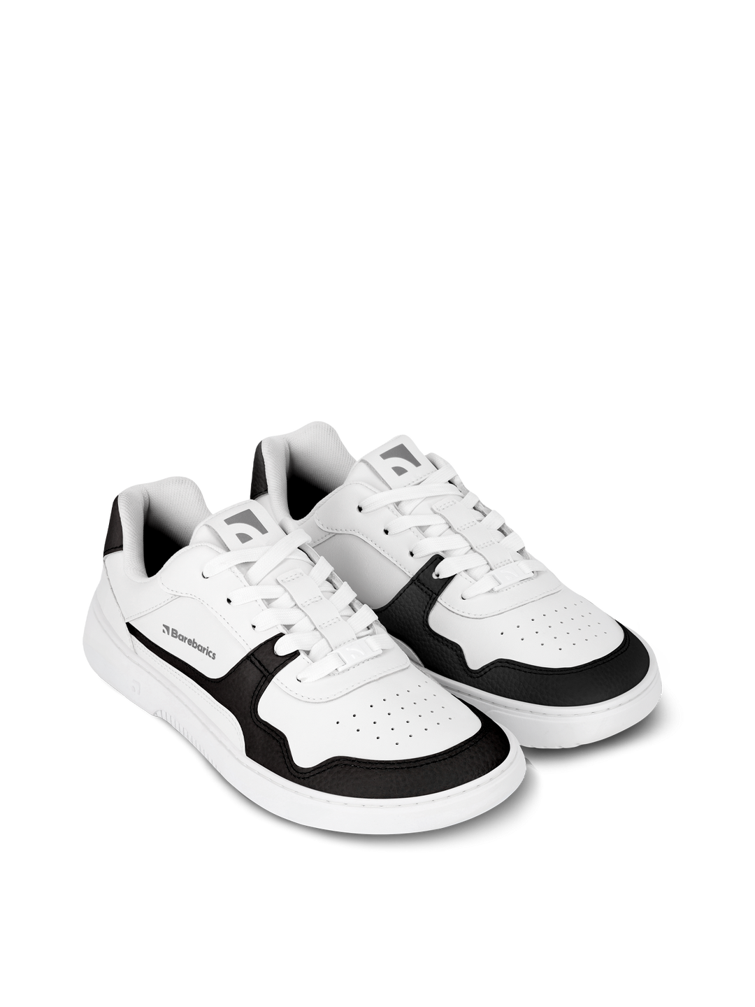 The Barebarics Zing (Unisex) sneakers feature a white design with black accents on the sides, toe, and heel, made from sustainable leather. These low-cut shoes offer barefoot-quality comfort and are shown against a plain white background.