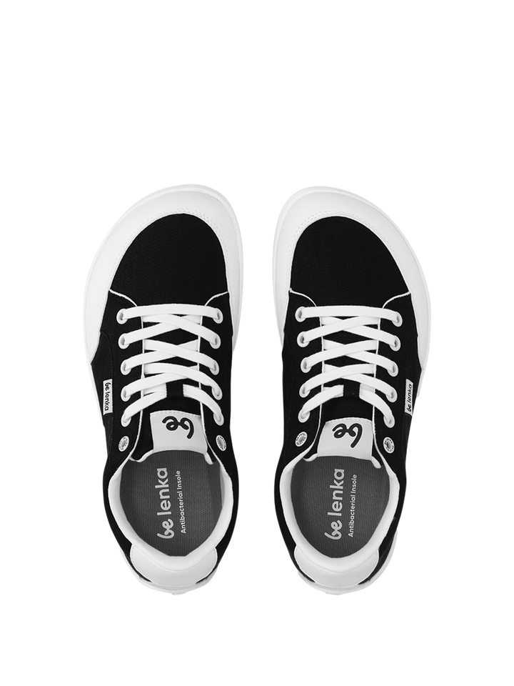 A pair of BeLenka Rebound (Unisex) black and white retro sneakers with white laces and soles is shown from above, side by side on a plain white background. The insoles are branded with “be lenka.”.