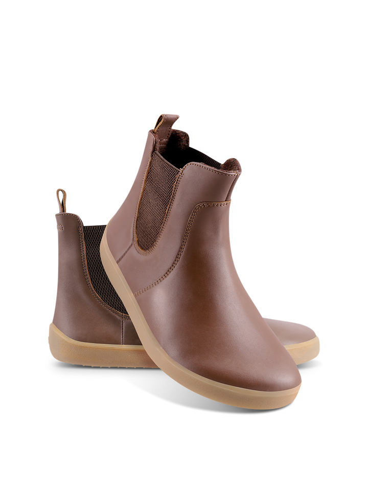 A pair of BeLenka Entice Neo (Unisex) brown slip-on ankle barefoot boots with a wide toe box, elastic side panels, and light tan rubber soles, displayed against a white background.