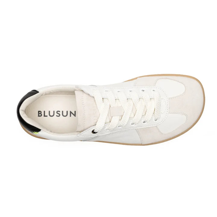 BLSN-200 (Women’s) by BluSun is a white sneaker with white laces, beige accents, and a light brown sole, shown from above. The insole displays the BluSun logo, while the inner heel area features a black section. Expertly handcrafted in Portugal, this barefoot sneaker offers enhanced comfort with its organic cotton lining.
