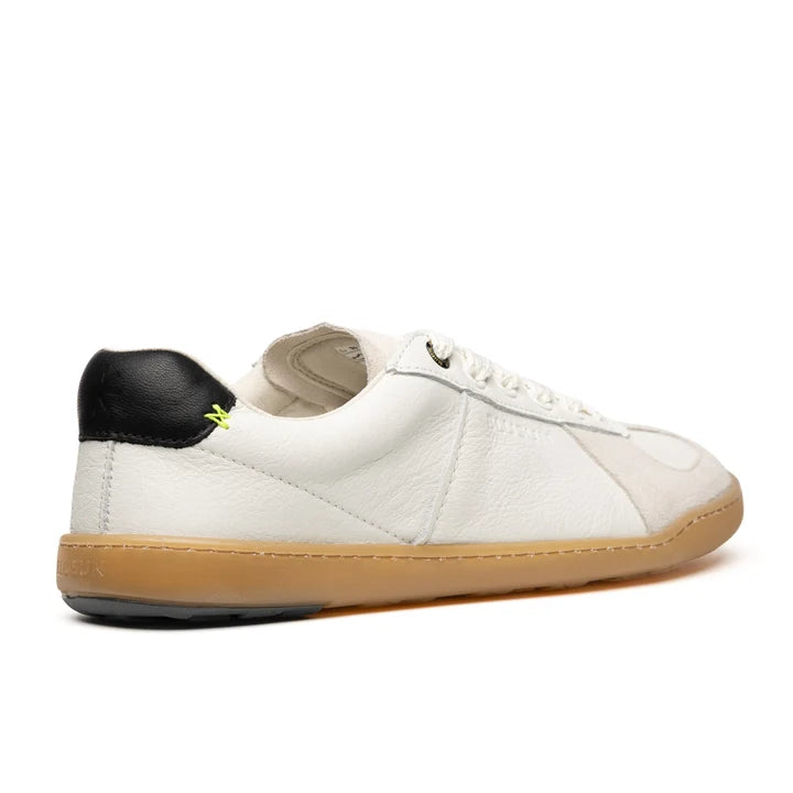 The BluSun BLSN-200 (Men’s) is a barefoot sneaker handcrafted in Portugal, featuring a white upper, black heel tab, gum sole, white laces, and a subtle neon yellow stitch detail near the heel. The shoe is shown from a rear side angle against a white background.