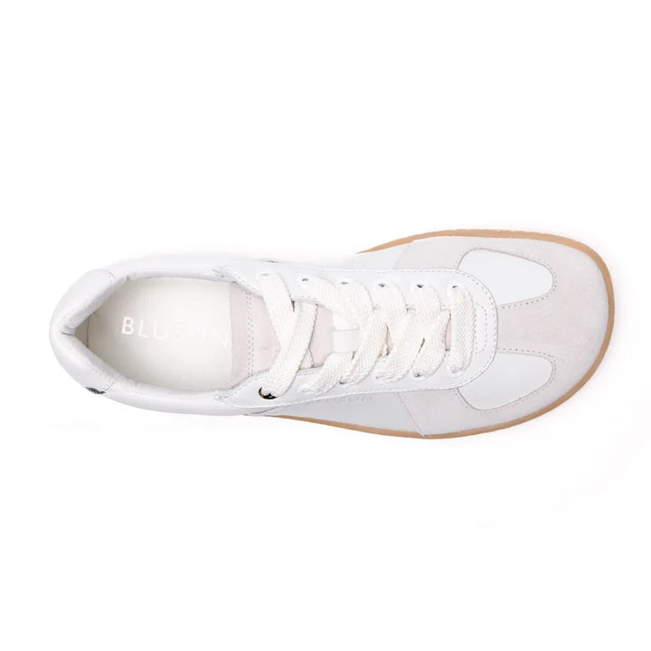 Top view of the BluSun BLSN-200 (Men’s) sneaker in white, featuring white laces, light grey suede accents, a white tongue, and a tan rubber sole. Expertly crafted with LWG Gold-certified leather for sustainable style, this design also includes an insole with “BLUS” partially visible in light lettering.