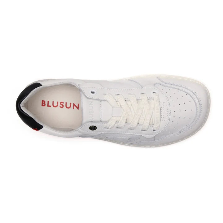 Introducing the BluSun BLSN-600+ (Men’s) barefoot sneaker in white, featuring a perforated toe, white laces, and a contrasting black heel tab. Designed for natural comfort with a wide toe box for plenty of space, this stylish shoe displays the BLUSUN logo in red on the insole. The sneaker is showcased from above against a plain white background.