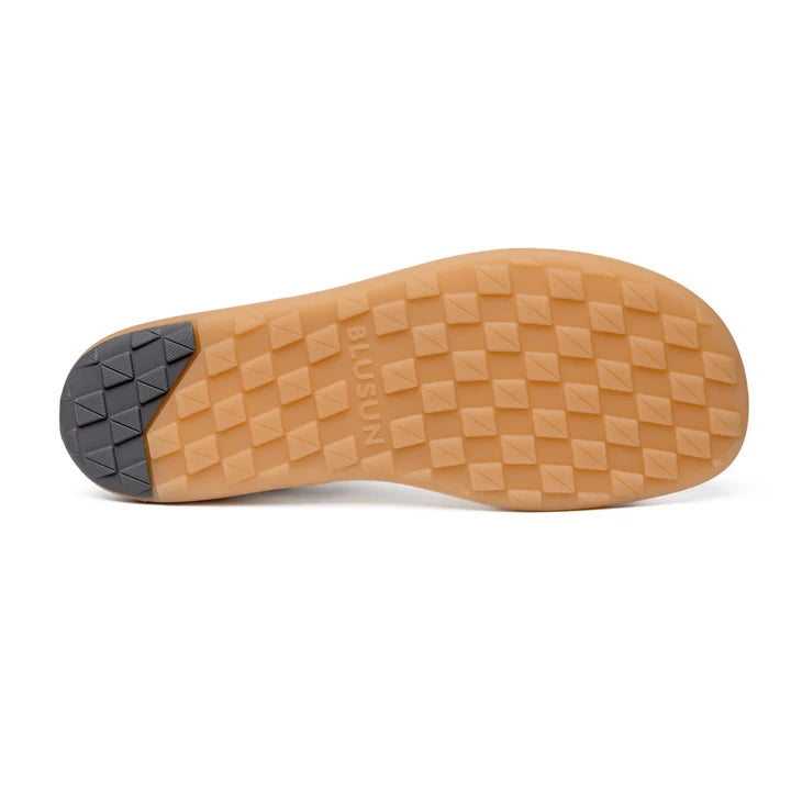 The image shows the sole of the BluSun BLSN-200 (Men’s) sneaker, featuring a white base with a tan diamond-patterned tread and a black textured heel section. Incorporating barefoot technology, the design emphasizes natural movement and comfort. The word BIUSUN is embossed on the sole near the center.