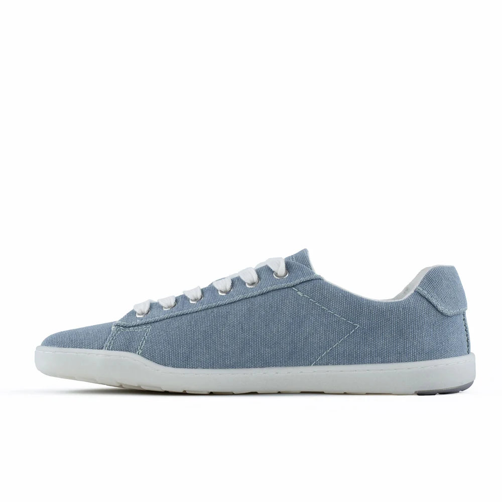 BluSun BLSN-103 (Women’s) light blue canvas sneaker, featuring a white sole and white laces, is displayed in a side profile on a plain white background. Made from organic cotton, this shoe offers sustainable design and barefoot comfort.