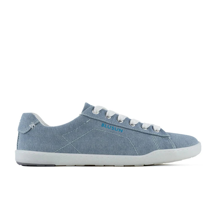 The BluSun BLSN-103 (Men’s) is a light blue canvas sneaker featuring white laces, white stitching, and a white rubber sole, with “BluSun” written in blue on the side. Designed as vegan men’s shoes, this style seamlessly blends comfort with ethical fashion. The shoe is shown in a side view against a white background.