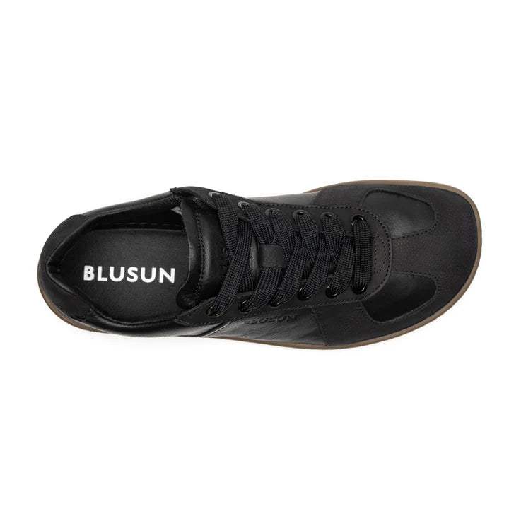 Top view of a black lace-up sneaker called BLSN-200 (Men’s) with the BluSun brand name printed in white on the insole. The shoe features a round toe, a smooth finish, and an organic cotton lining for enhanced comfort.