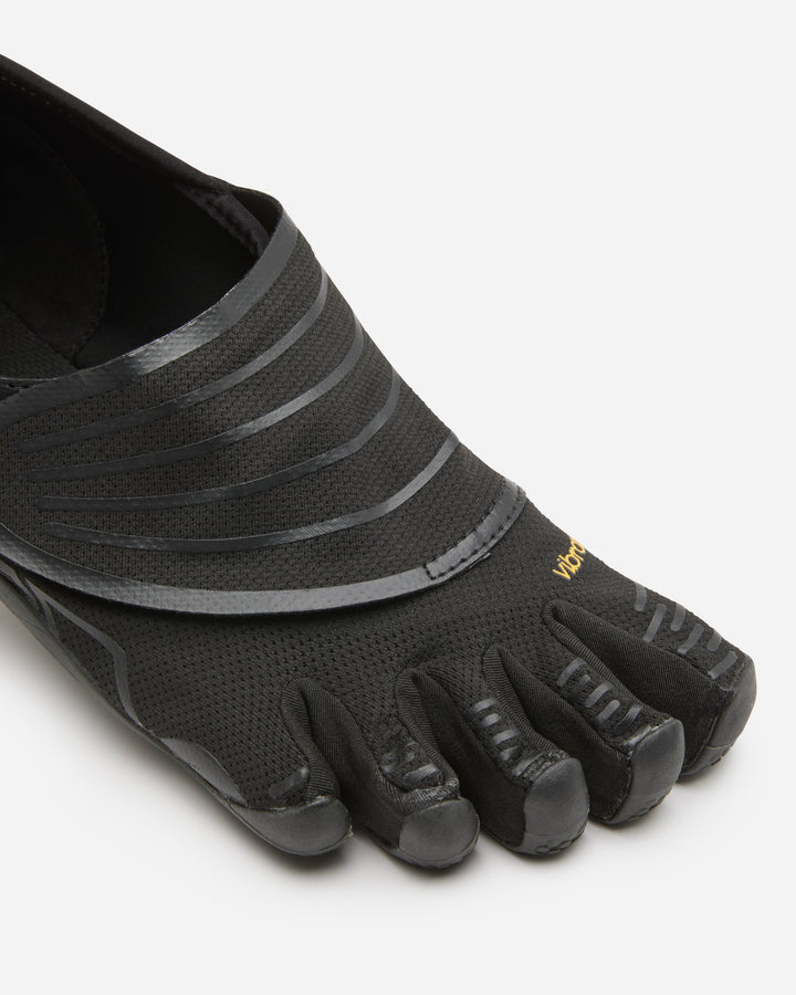 A close-up of the Vibram Groundsplay (Women's) shoe in black, featuring individual toe compartments, textured uppers, rubberized toe covers for strength training, and "Vibram" in yellow near the toes.