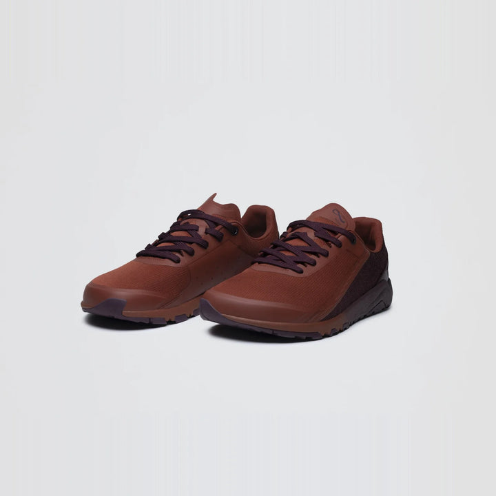 A pair of Notace Yama T1 men’s trail shoes in brown, featuring dark soles and laces and engineered for all-day comfort, is displayed at a slight angle against a plain white background.