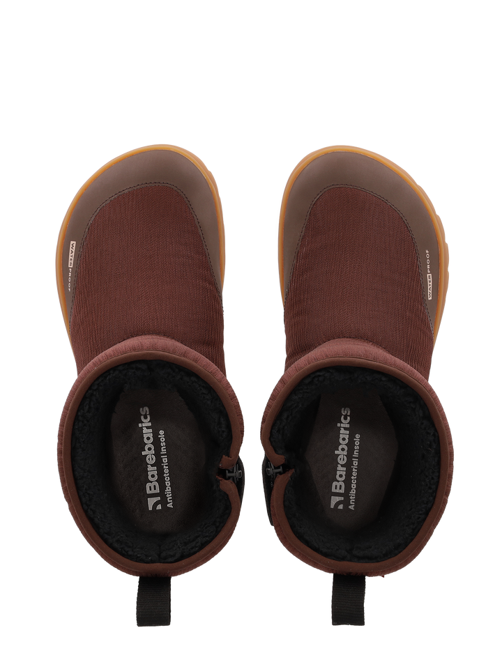 Top view of Barebarics Polarstride (Women's) brown slip-on winter boots with black inner lining, tan rubber soles, pull tabs at the back, insoles branded Barebarics Adventure Inside, and a waterproof membrane for extra protection.