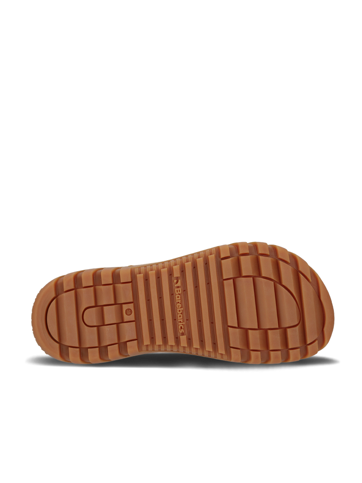 The image shows the bottom view of a brown rubber sole with deep grooves and ridges for traction, ideal for the Barebarics Polarstride (Women's) winter boot. "Barebarics" is embossed in the center, set against a plain white background.